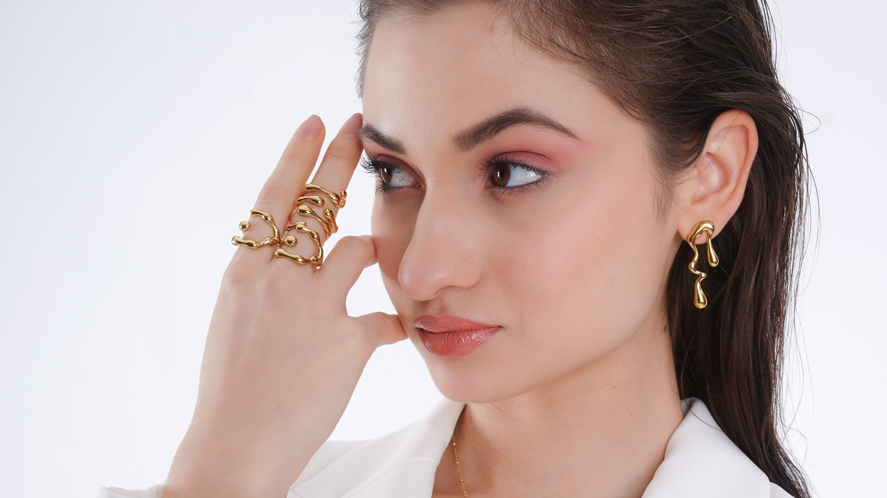 Woman wearing 18K gold-plated statement ring and molten drop earrings — demi-fine jewellery styled with modern elegance.