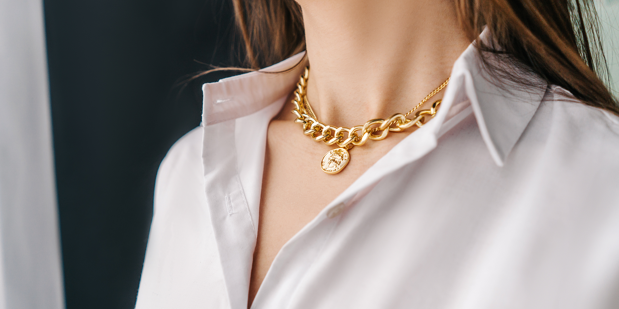 Woman wearing 18K gold-plated chunky chain necklace with a medallion pendant, styled over a white collared shirt – Embrell summer jewelry