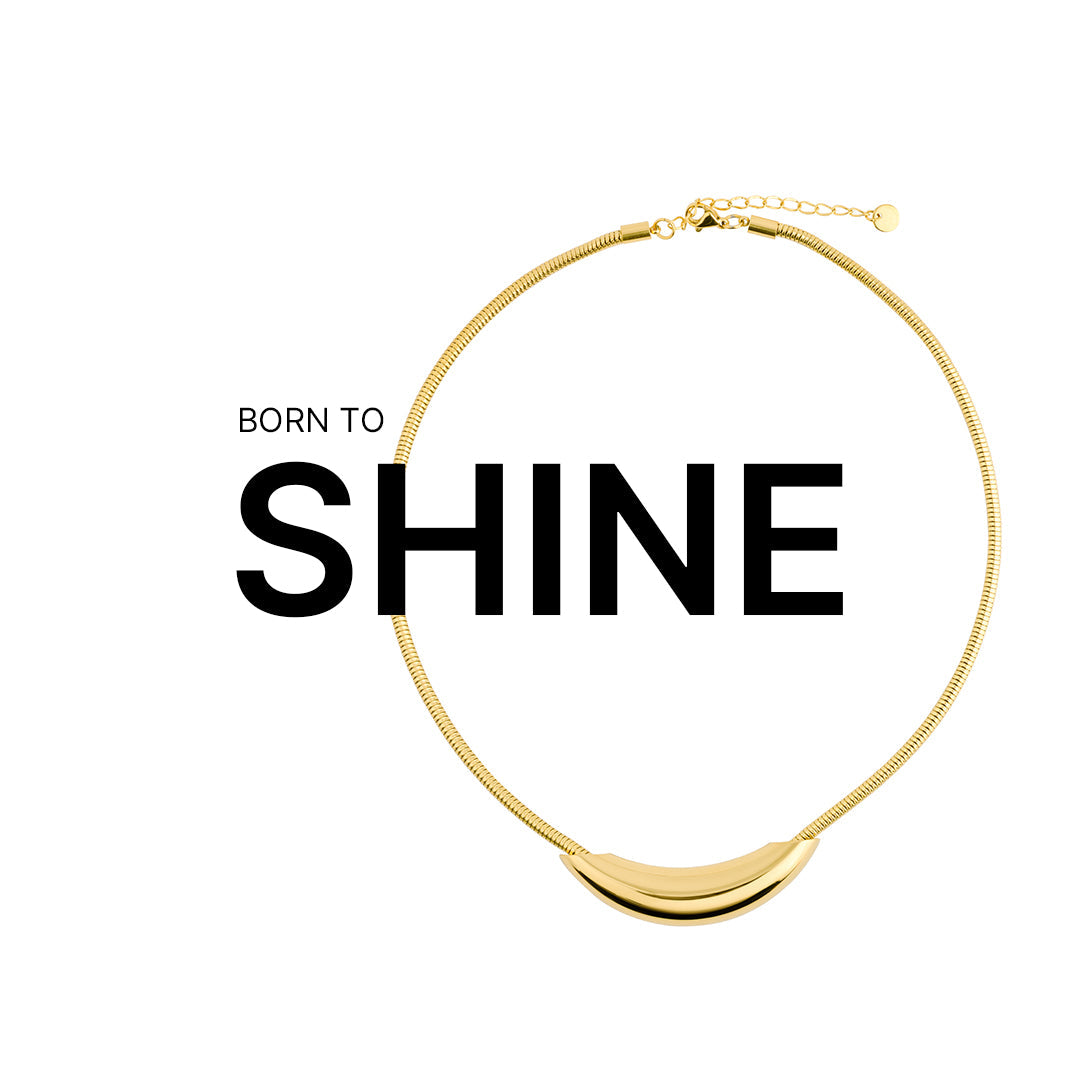 Sleek 18K gold-plated necklace with a curved, polished pendant and snake chain design, showcased with the text "BORN TO SHINE," where the necklace subtly wraps around the bold word "SHINE" on a white background.