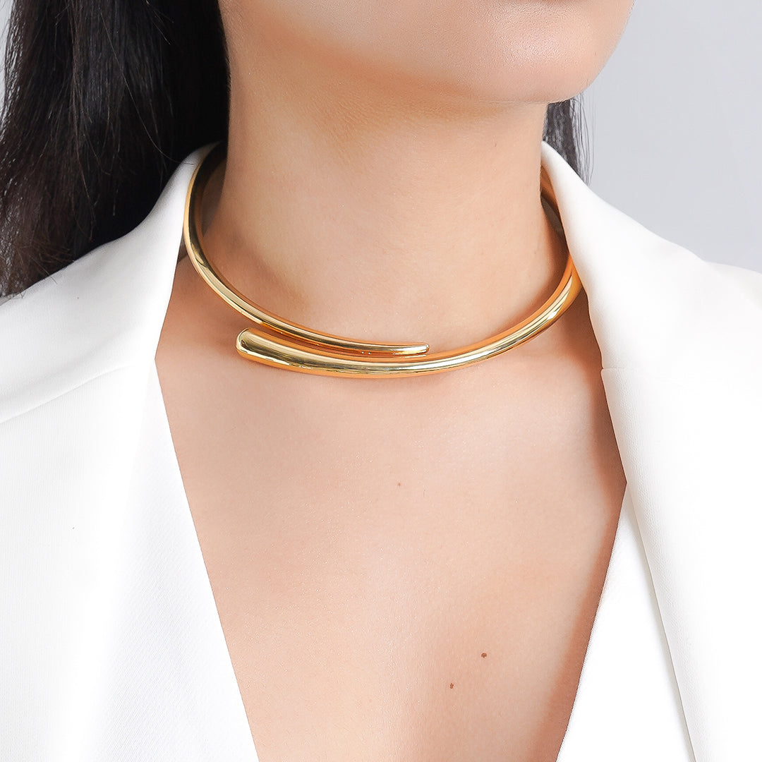 A woman models a 18K gold plated choker necklace, showcasing its elegant design against her skin.