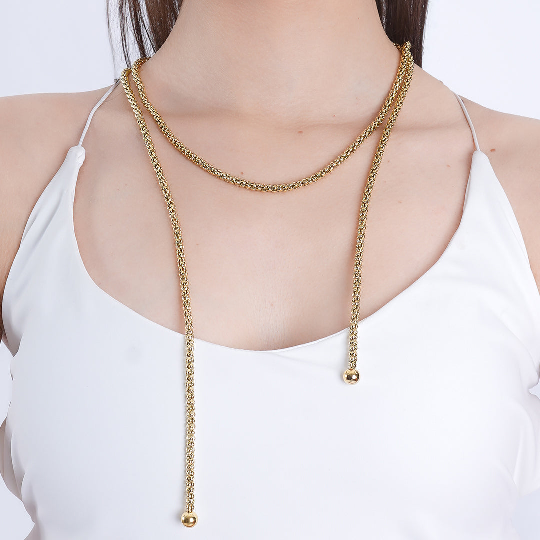 A woman wearing a 18K gold plated chain necklace, showcasing its elegant design against her outfit.