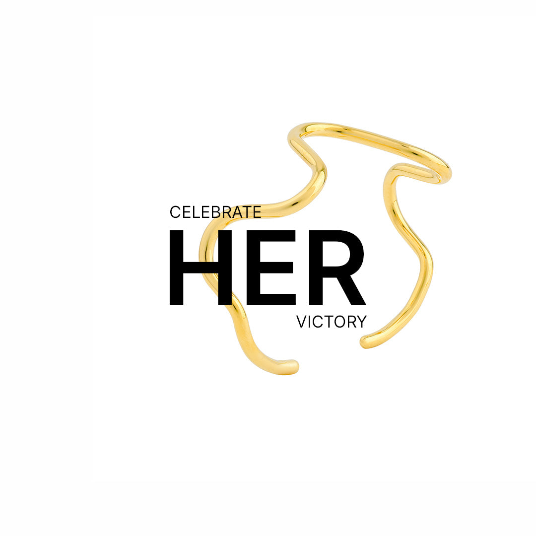 Abstract 18K gold-plated open ring with fluid, wave-like curves, displayed on a white background with the bold message "CELEBRATE HER VICTORY" — the artistic design intertwines with the word “HER” to emphasize empowerment and elegance.