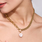 Gold chain necklace with a pearl pendant worn by a women