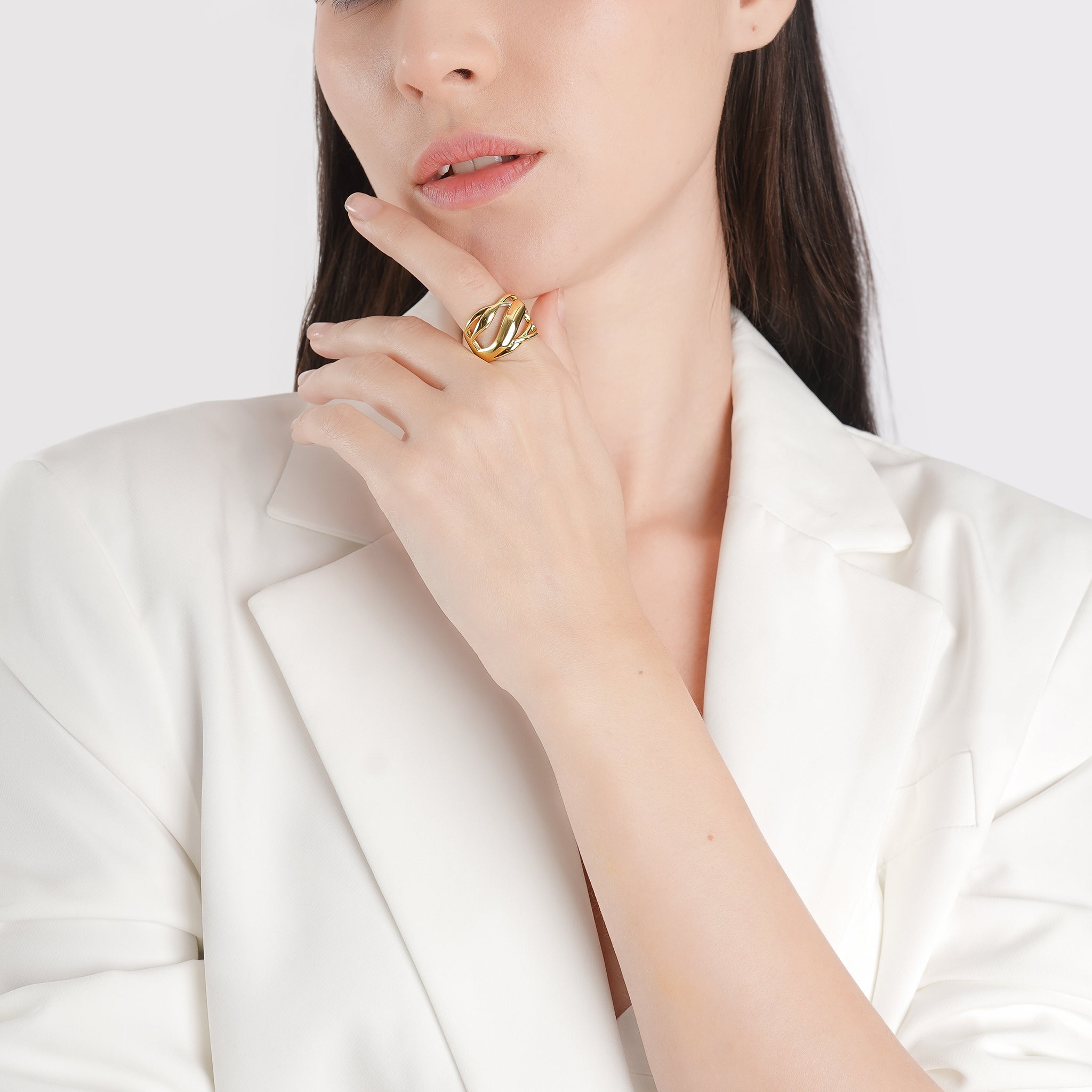 Model wearing an 18K gold-plated open ring with a flowing cutout design, adding a modern, polished touch to her minimal outfit.