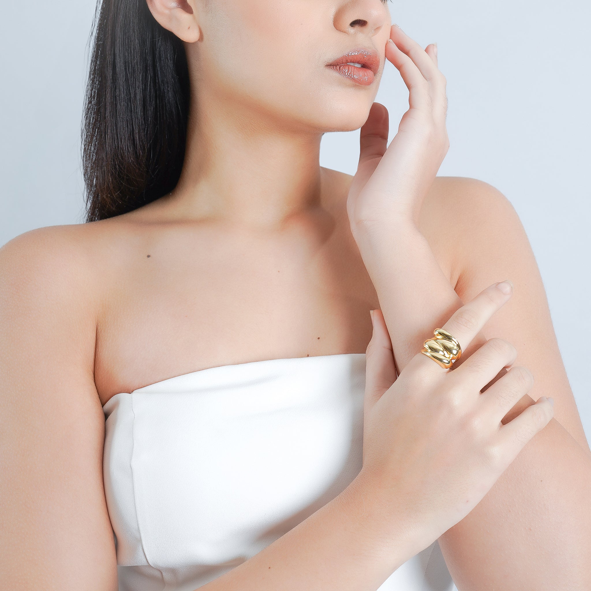 Model wearing an 18K gold-plated statement ring with layered, flowing curves, adding a bold yet refined touch to her minimalist look.