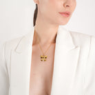 Model wearing an 18K gold-plated necklace with a bow-shaped pendant, adding a playful and elegant accent to her chic outfit.