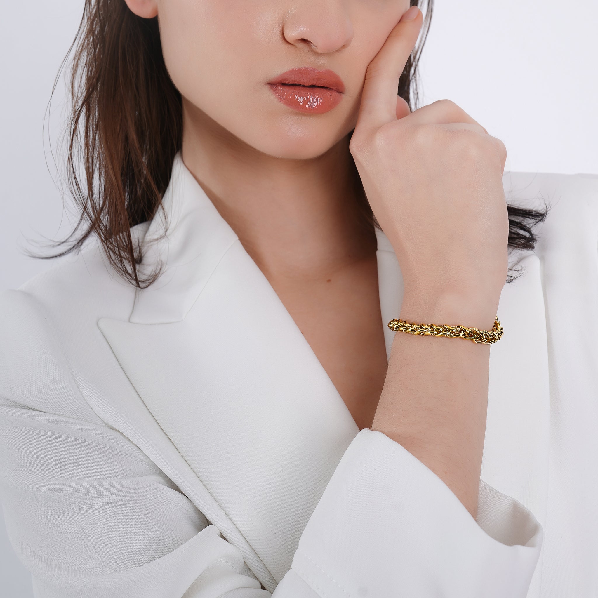 Model wearing an 18K gold-plated braided chain bracelet with a polished finish, adding a sophisticated touch to her elegant attire.