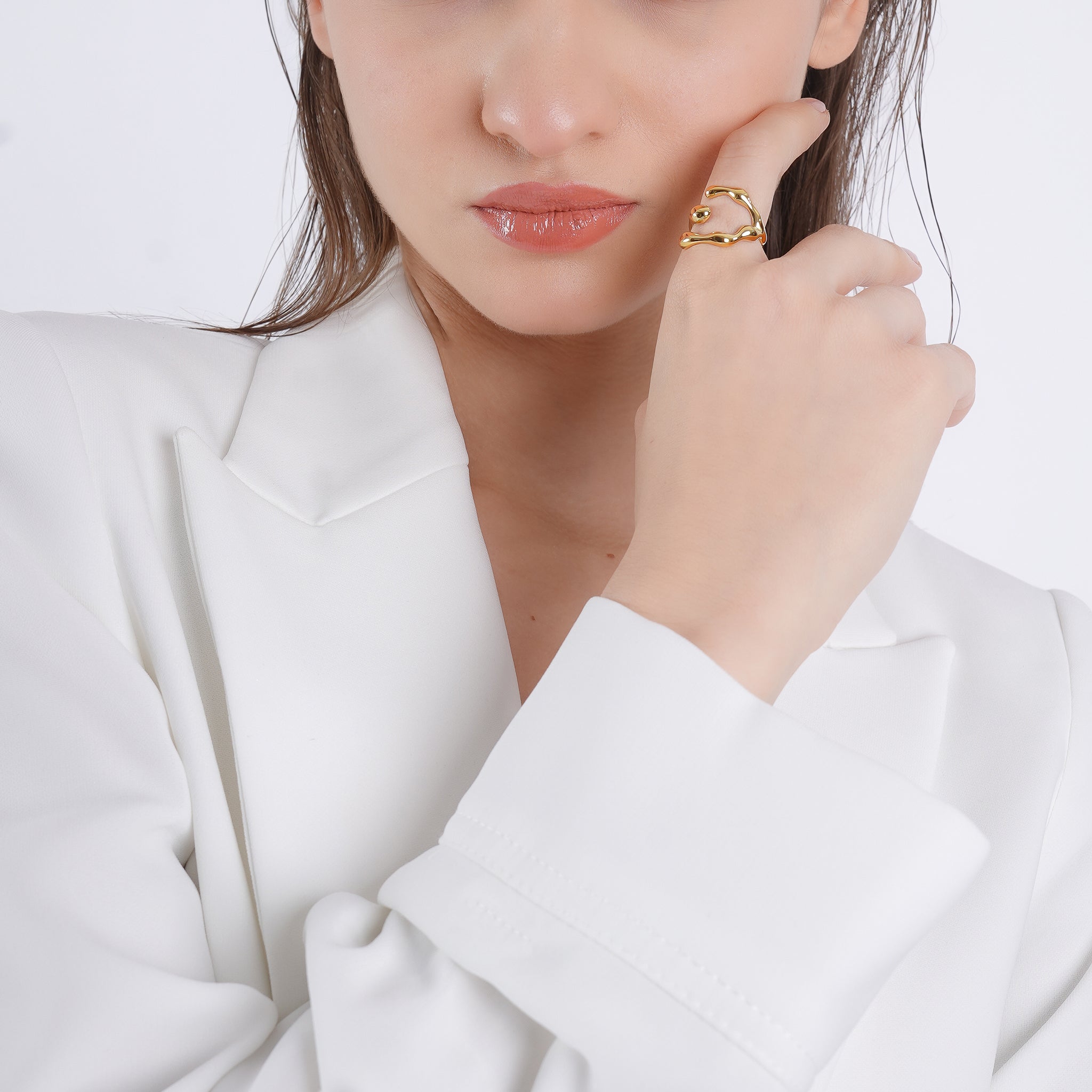 Model wearing an 18K gold-plated abstract open ring with organic curves, adding a modern, artistic touch to her elegant outfit.