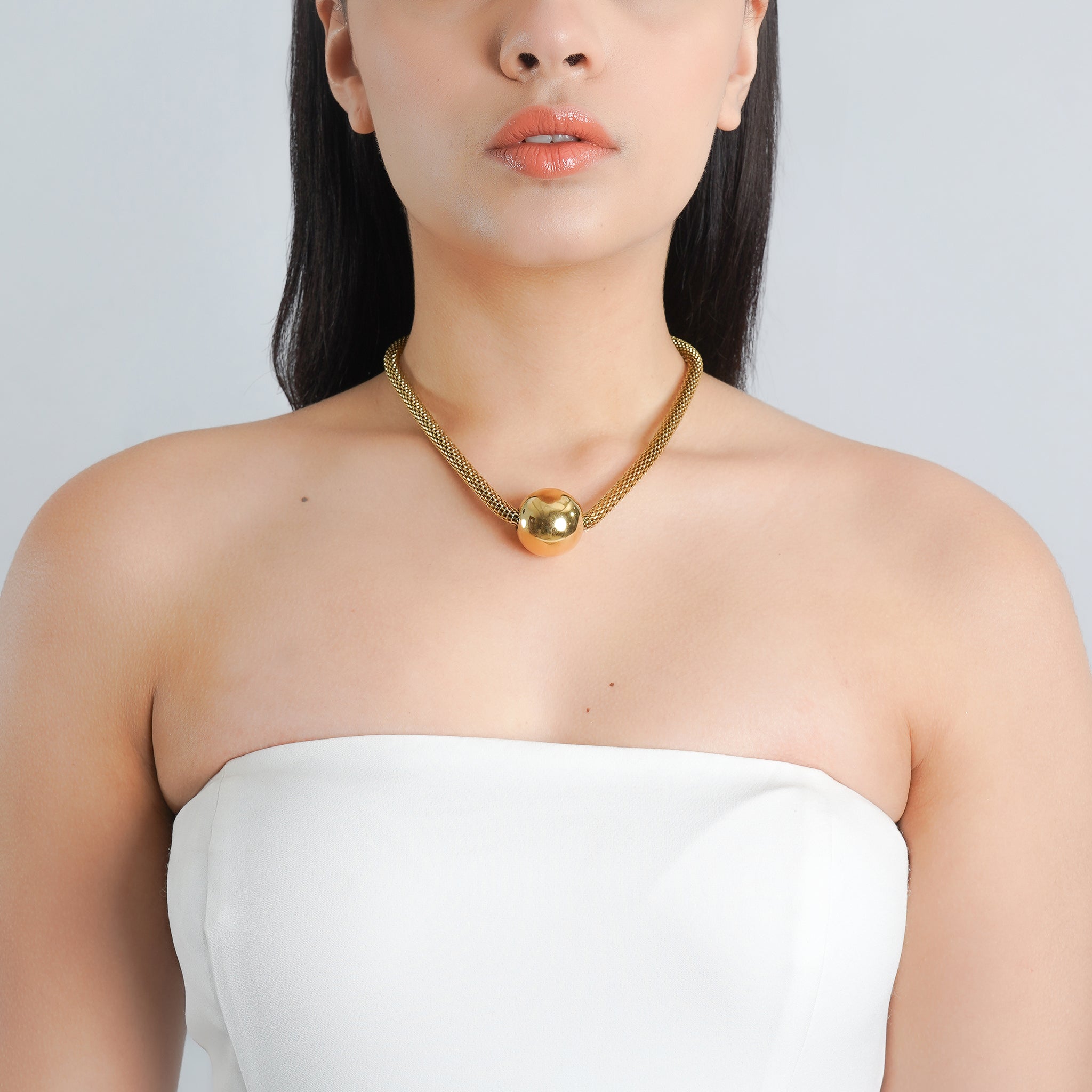 18K gold-plated mesh chain with a bold spherical pendant, adding a contemporary edge to your style.