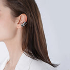 A model wearing silver plated ear cuffs, styled in a sleek and modern fashion, accentuating the ear with a bold and elegant touch.