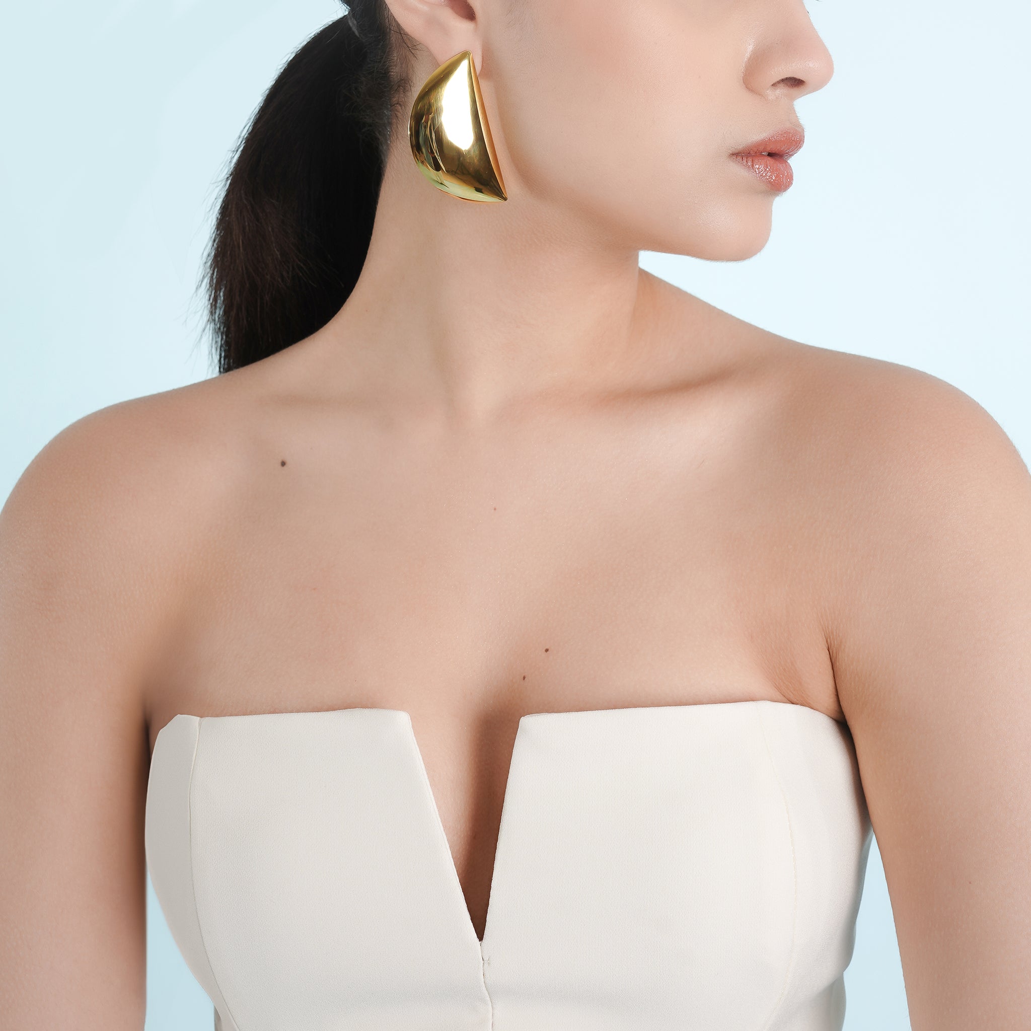 Model wearing 18K gold-plated semi-circle statement earrings, highlighting the bold and contemporary design with a luxurious shine.