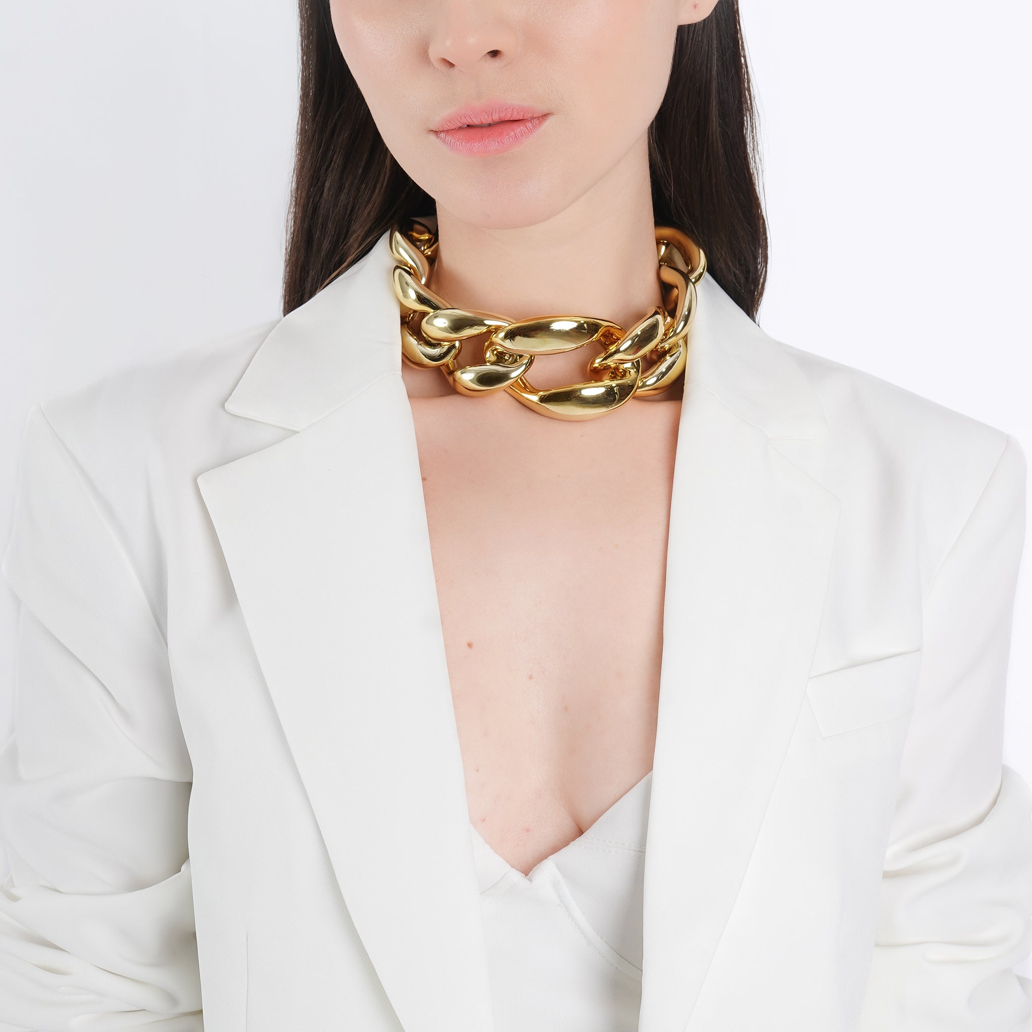 Model wearing the gold-plated chunky chain choker with bold interlocking links, styled with a white blazer, highlighting its statement look and glamorous appeal.