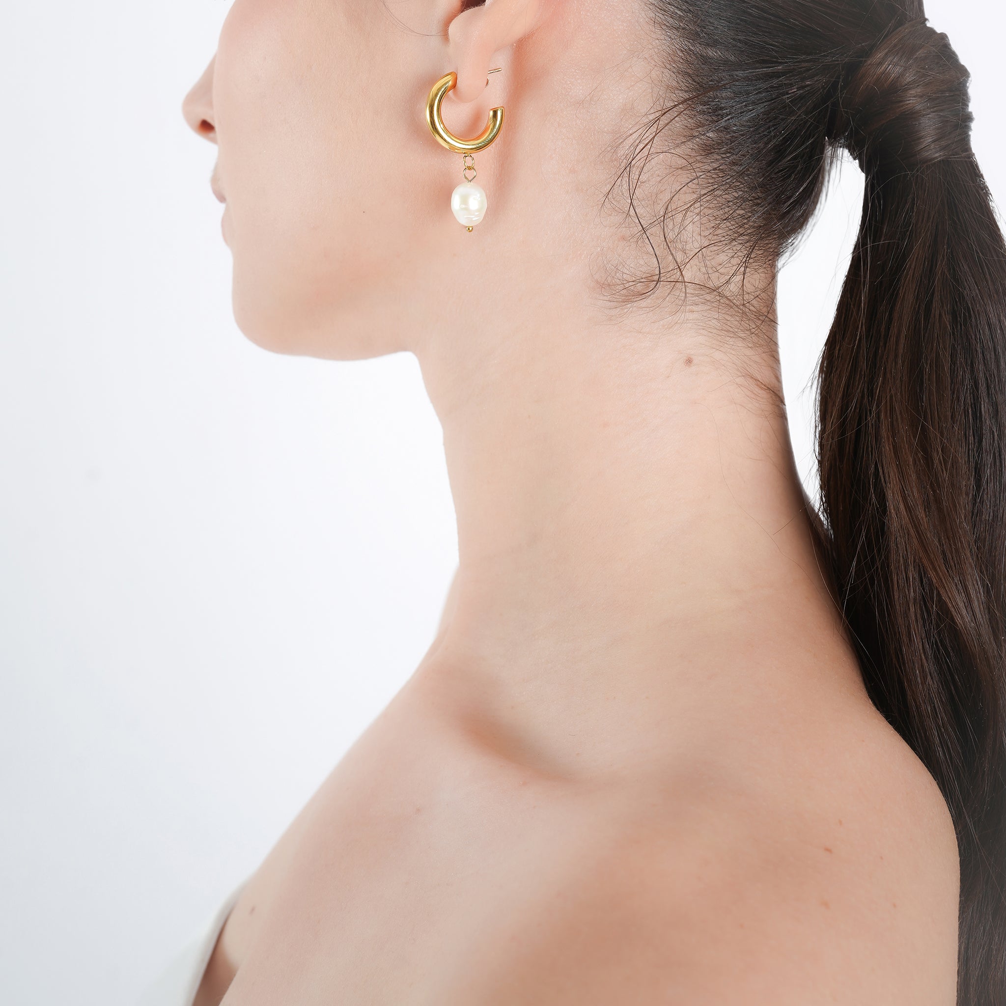 Model wearing 18K gold-plated hoop earrings with dangling pearls, styled to highlight their refined look and versatile elegance, perfect for both formal and casual wear.