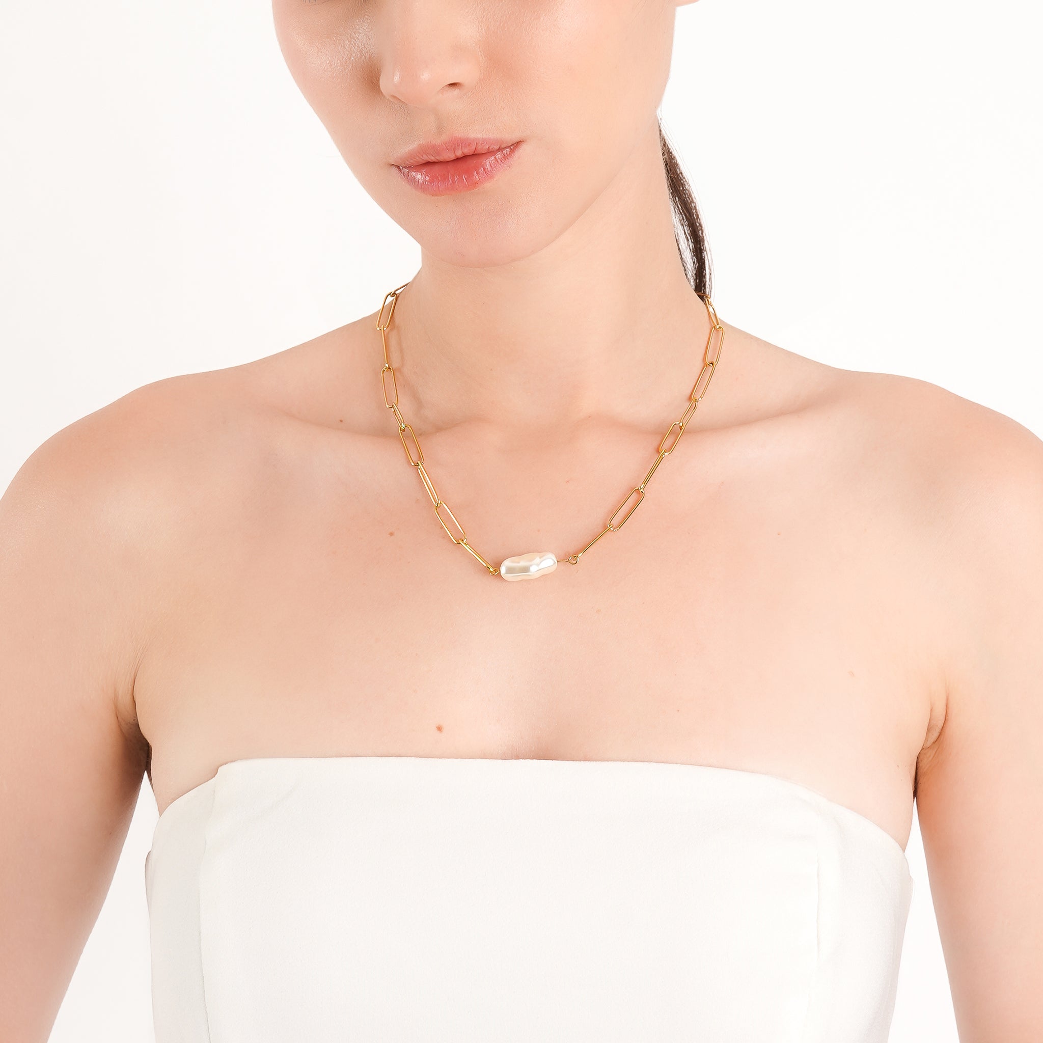 Model wearing the 18K gold-plated paperclip chain necklace with a freshwater pearl pendant, styled with a strapless white top for a simple and refined look.
