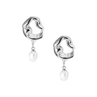 A pair of silver-plated earrings featuring sculptural, wavy open-loop designs, adorned with dangling freshwater pearls for an artistic yet luxurious finish.