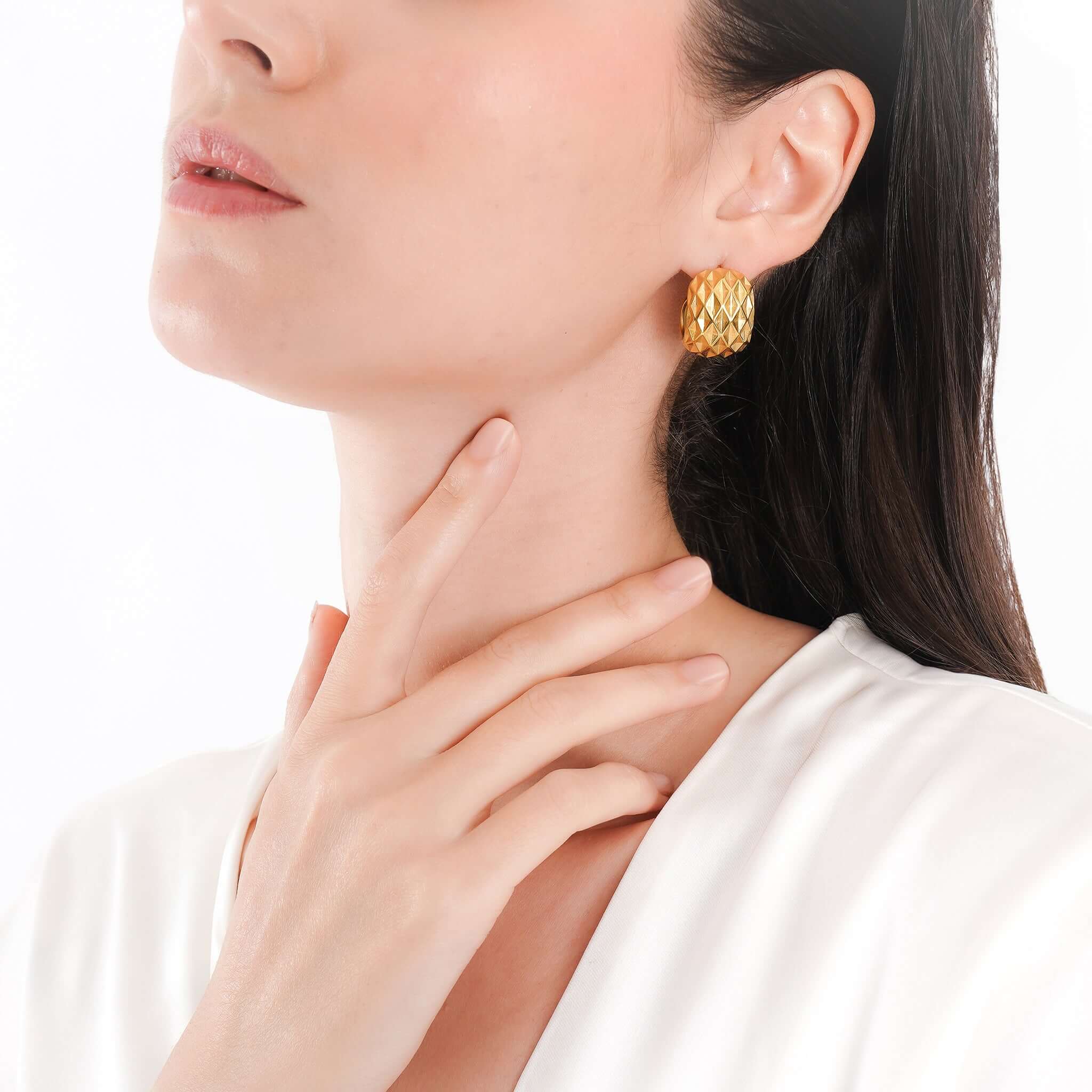 Model wearing the 18K gold-plated textured hoop earrings styled with a white blouse, highlighting their bold elegance and refined appeal.