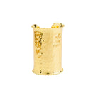 A model wearing the bold, hammered gold cuff bracelet on her wrist, complementing her elegant white outfit.