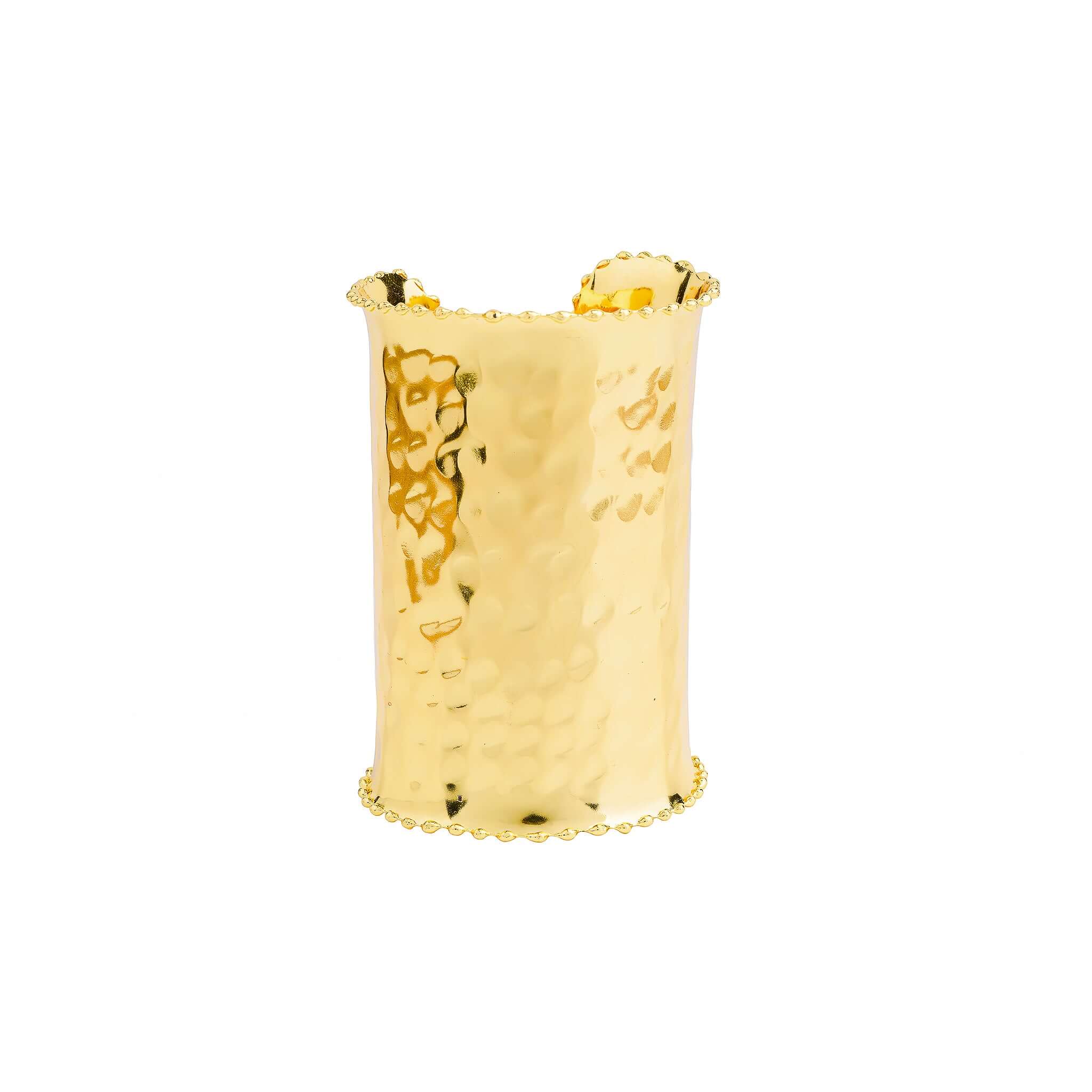 A model wearing the bold, hammered gold cuff bracelet on her wrist, complementing her elegant white outfit.