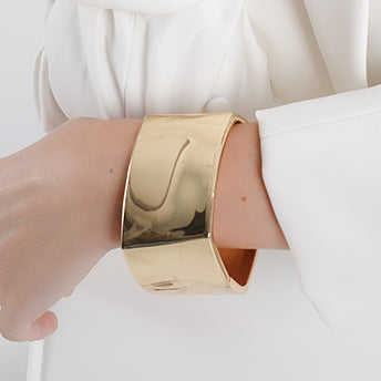 Bold 18K gold-plated cuff bracelet with a wide, high-shine surface and a sleek, sculptural design. A statement piece that exudes modern elegance and sophistication.